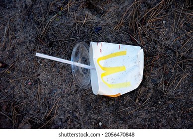 Discarded Mcdonalds Paper Cup, Cola And Fast Food Packaging On The Ground. People Left Behind Trash. Fast Food Rubbish. Russia, Moscow, 04.10.2021.