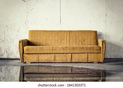 Discarded Old Brown Sofa Against Dirty Wall