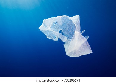 A discarded plastic bag floating in open ocean.  Plastic pollution is a rapidly growing environmental problem.