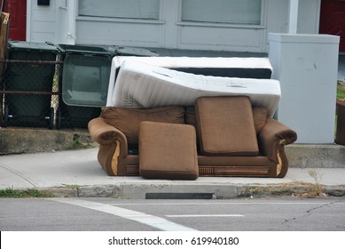 Discarded Sofa Left Out On The Sidewalk For Garbage Pickup In Impoverished Urban Neighborhood 