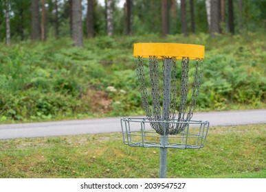 Discgolf park located in finland. Professional discgolf basket on the course. Target for throwing discs. Basket with lots of chains for best catching properties. Discgolf course by the road.