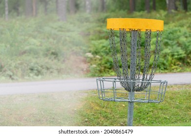Discgolf park located in finland. Professional discgolf basket on the course. Target for throwing discs. Basket with lots of chains for best catching properties. White side on the left