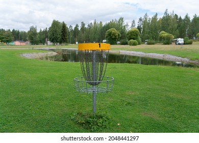 Discgolf park located in finland. Professional discgolf basket on the course. Target for throwing discs. Basket with lots of chains for best catching properties. Discgolf course by the lake