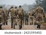 A disciplined and specialized military unit, donned in camouflage, strategically patrolling and maintaining control in a high-stakes environment, showcasing their precision, unity, and readiness for