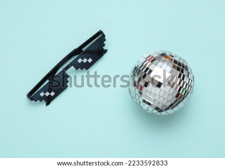 Disco ball with Pixelated 8 bit sunglasses on blue background