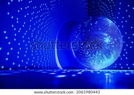 Disco ball reflecting blue light in a dark hall for discos. Disco on the floor. Copy space.