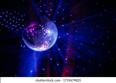 Disco ball scatters blue light in a dark room
