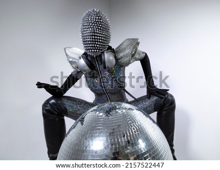 A disco dancer with spiky mask and silver costume against colourful background masquerade 