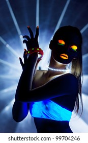 Disco girl with glow make-up dance in uv light