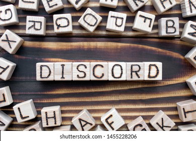 discord wooden cubes with letters, disagreement mistrust concept, around the cubes random letters, top view on wooden background