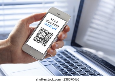 Discount coupon with QR code on smartphone with laptop in background - Powered by Shutterstock - Get 15% off with code: PIKWIZARD15