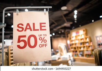 Discount percentage sign display in  fashion department store during sale season period. Sale tag of offering special promotion hanging in shopping mall, Blurred department store background.