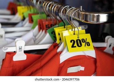 Discount sale tags, 20, 30, 50% off, on hangers with clothes in casual clothing store. Fashion concept, discount season, black friday, offline shopping, gimmicks, holiday sales. - Shutterstock ID 2046397706