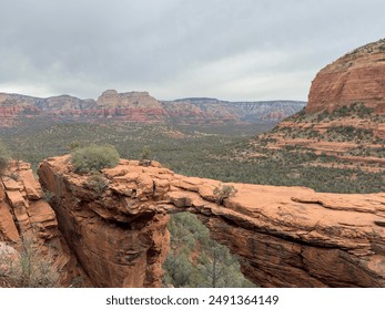 Discover the iconic Devil's Bridge in Sedona, Arizona, framed by stunning red rocks and sandstone cliffs. This scenic view showcases the natural arch and rugged terrain, ideal for outdoor adventure. - Powered by Shutterstock