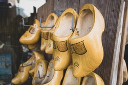 Discover The Timeless Dutch Tradition Of Yellow Clogs Adorning A Rustic Wooden Wall. These Iconic Shoes Symbolize The Rich Agricultural Heritage Of The Netherlands. A Traditional Farmer Footwear.