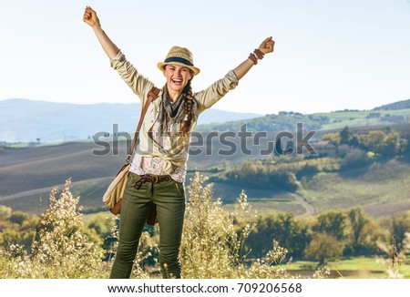 Discovering magical views of Tuscany. smiling active woman hiker in hat with bag on Tuscany hike rejoicing