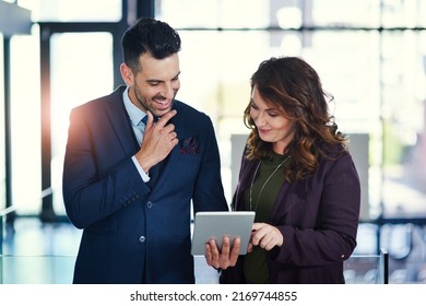 Discovering A World Of Bold Ideas Online. Shot Of Two Businesspeople Using A Digital Tablet Together In An Office.