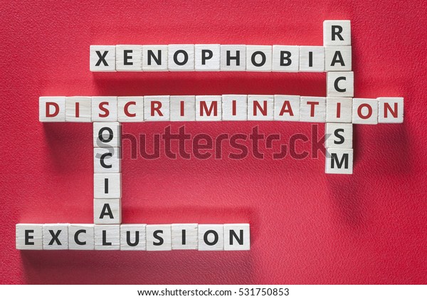 Discrimination,\
xenophobia, racism and social exclusion words written with blocks\
on red background. Social issues\
concept