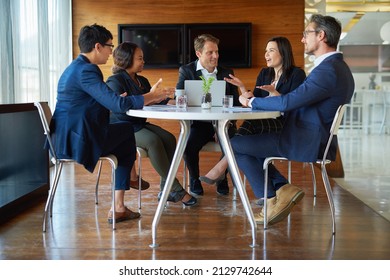 Discussing The Best Way Forward. Shot Of A Group Of Corporate Businesspeople Working In The Boardroom.