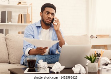 Discussing Document. Serious African-american Man Holding Paper And Talking On Mobile Phone, Working At Home Office, Copy Space