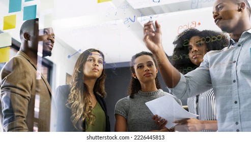 Discussing new ways to increase productivity. Cropped shot of a diverse group of businesspeople brainstorming on a glass wall in a modern office. - Shutterstock ID 2226445813