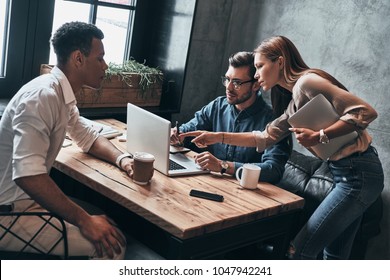 Discussing Strategy. Top View Of Young Confident Business People Discussing Something While Spending Time In The Office