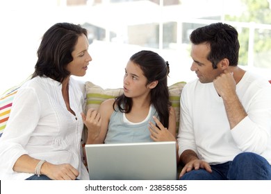 Discussion between teenage girl using laptop and her parents