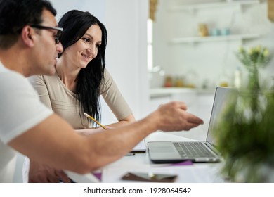 Discussion. Side View Of Middle Aged Latin Couple, Man And Woman Communicating During Online Training Course While Studying Remotely, Using Laptop At Home