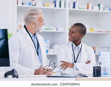 Discussion, team and pharmacists with medication in pharmacy for healthcare or medical career. Conversation, medicine and senior chemist mentor talking to female pharmaceutical student by dispensary. - Powered by Shutterstock