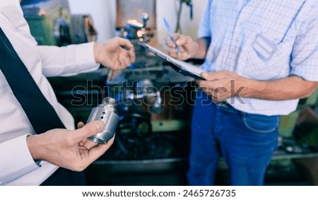 Discussion in technical office with drawings, quick connect steel fittings for hydraulic hoses.