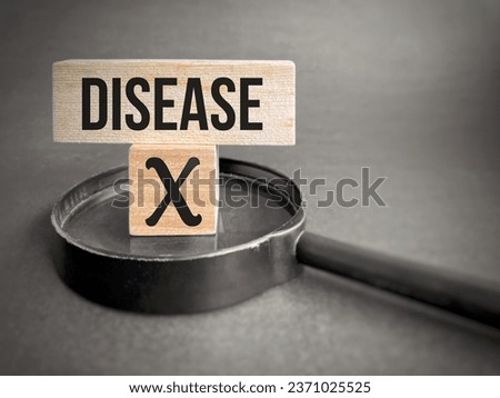Disease X on wooden blocks with magnifying glass. The next unknown deadlier pandemic, threat of another variant and pathogen. 