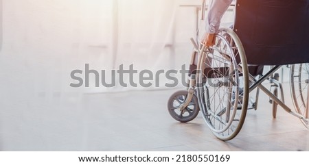 diseased man is sitting in a wheelchair, He holds his hands on the wheel wheelchair Recovery and healthcare concepts.