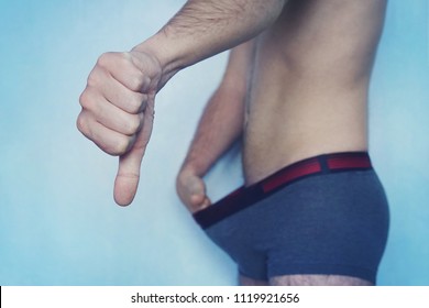 Diseases In The Urogenital Sphere Of Men.. Man Shows His Thumb That He Has A Small Penis. The Concept Of Impotence. Impotent Looks At His Cock