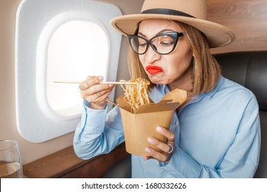 Disgruntled Passenger In Business Class Tries And Sniffs Spoiled Food On The Plane. The Concept Of Changes In The Sense Of Smell And Taste Buds And Poor Service In The Airline