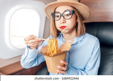 Disgruntled Passenger In Business Class Tries And Sniffs Spoiled Food On The Plane. The Concept Of Changes In The Sense Of Smell And Taste Buds And Poor Service In The Airline