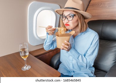 Disgruntled Passenger In Business Class Tries And Sniffs Spoiled Food On The Plane. The Concept Of Changes In The Sense Of Smell And Taste Buds And Poor Service In The Airline