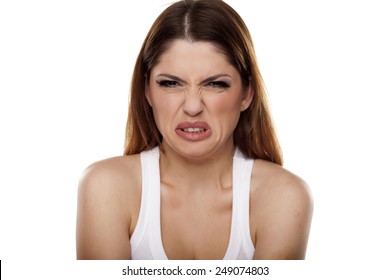 disgusted and frowning young woman on a white background