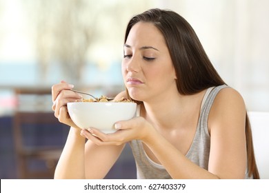 Disgusted Woman Eating Cereals With Bad Taste At Home