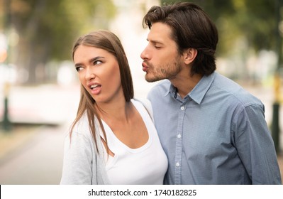 Disgusted Woman Rejecting To Kiss Man Having Bad Date Walking Outdoors In Park. Unanswered One-Sided Love Concept