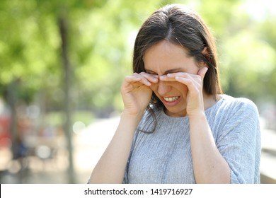 Disgusted Woman Rubbing Her Eyes Standing Outdoors In A Park