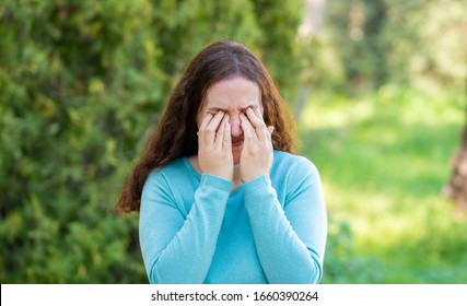 Disgusted Woman Rubbing Her Eyes In A Park