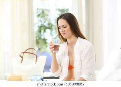 Disgusted Woman Tasting Water With Bad Flavour In An Hotel Room On Summer Vacations