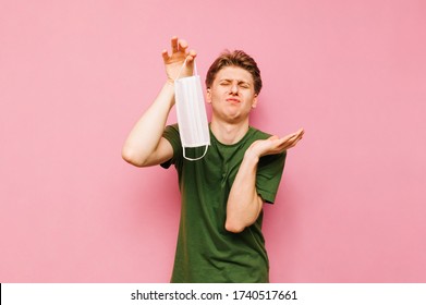 Disgusting young man removes a protective gauze mask from his face with an evil face. Angry guy unhappily removes the mask from his face, isolated on yellow. - Shutterstock ID 1740517661