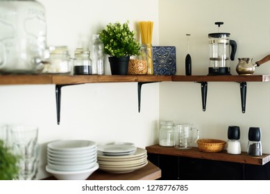 Dish and decorations on open wooden shelves in white kitchen - Shutterstock ID 1278776785