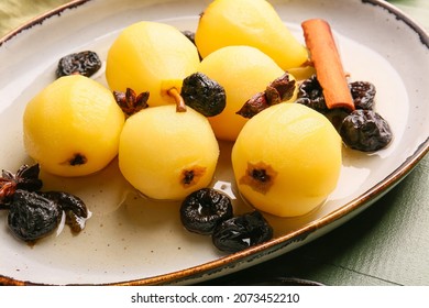 Dish with delicious poached pears, prunes, anise and cinnamon on color wooden table, closeup
