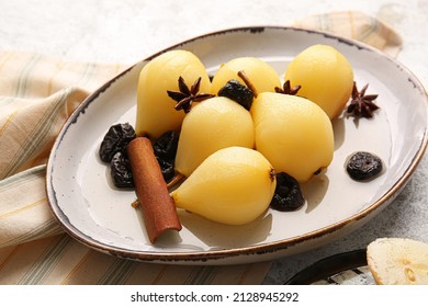 Dish with delicious poached pears, prunes, anise and cinnamon on light table