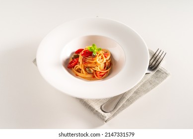 Dish of delicious spaghetti with pachino tomatoes and olives, Italian food 