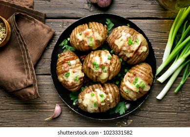 Dish for dinner. Tasty baked potatoes with bacon, green onion and cheese on wooden background. Top view, flat lay food