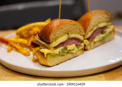 A Dish Of A Fancy Pastrami Burger With Homemade Chips