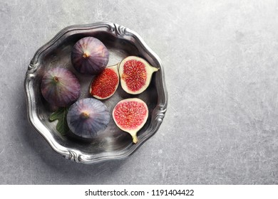 Dish with fresh ripe figs on gray background, top view. Space for text - Shutterstock ID 1191404422